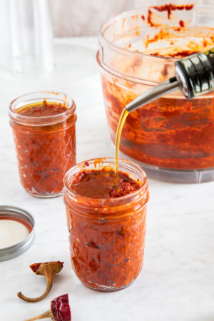 small jar filled with morrocan spicy chili paste harissa, and olive oil