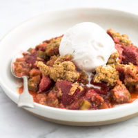 plate with gluten-free rhubarb strawberry crumble and a scoop of ice cream