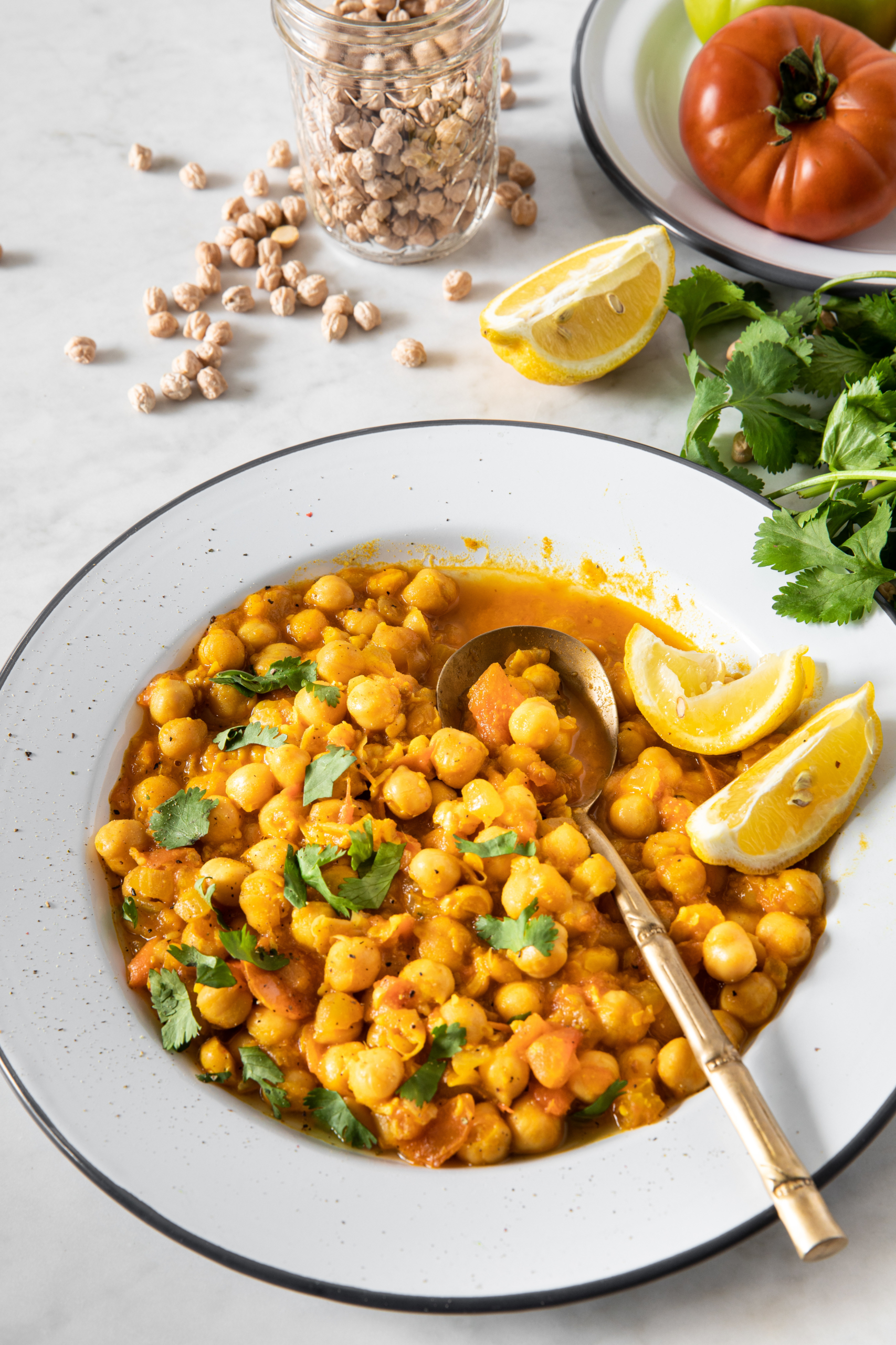 A plate of Quick Vegan Chickpea Tomato Curry served with cilantro and lemon wedge from verygoodcook.com