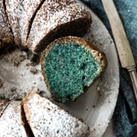 photo of a sliced poppy seed bundt cake, view from above, on a plate with a knife and napkin | from verygoodcook.com